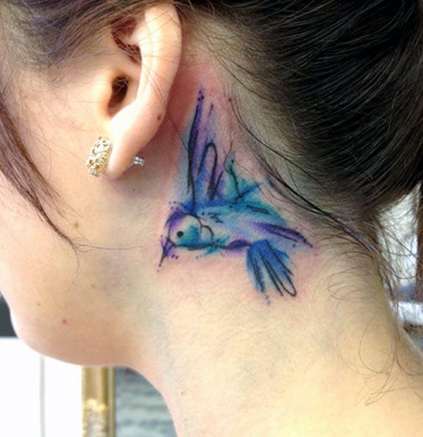 A charming little hummingbird tattoo design behind the ear for girls