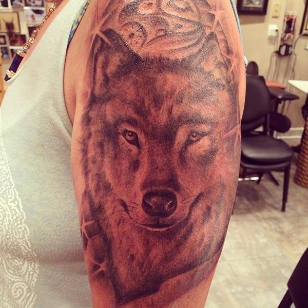 A mesmerizing wolf tattoo design on shoulder for women