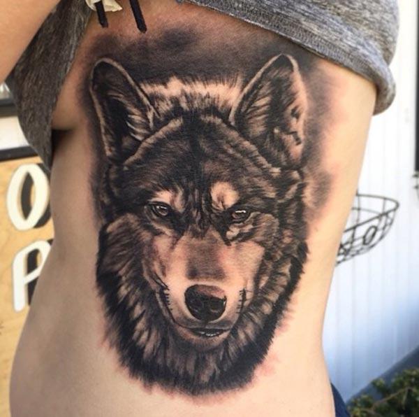 An exquisite wolf tattoo design on side belly for ladies